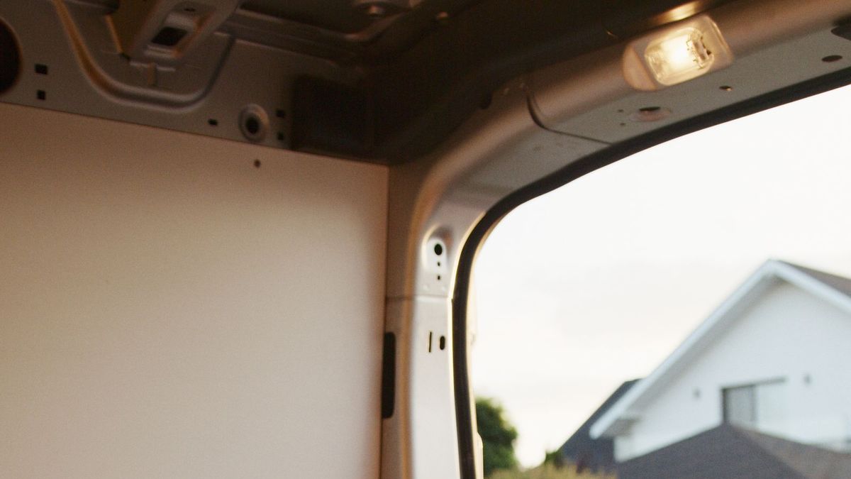 Looking out from inside a cargo van toward a suburban house
